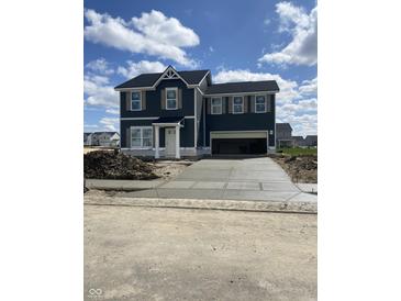 A two-story home with a dark exterior, shuttered windows and a concrete driveway under a partly cloudy sky at 7167 Finley Creek Dr, Whitestown, IN 46075
