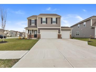 Two-story home featuring a three-car garage, neutral color siding and landscaped front yard at 8546 Strabet Dr, Pendleton, IN 46064