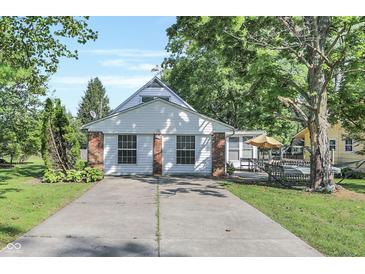 Charming house showcasing a brick and white wood exterior with a concrete driveway at 8553 Broadway St, Indianapolis, IN 46240