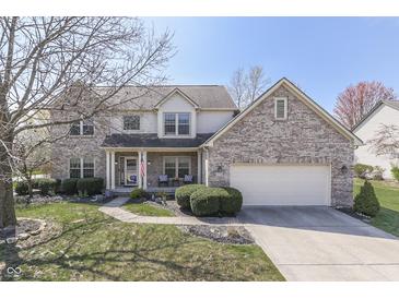 Charming two-story brick home with a well-manicured lawn and attached two-car garage at 9760 Logan Ln, Fishers, IN 46037