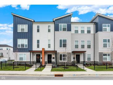 Modern townhome exterior with blue and grey siding and well-maintained landscaping with a black fence at 3123 Bolton Square Blvd, Indianapolis, IN 46222