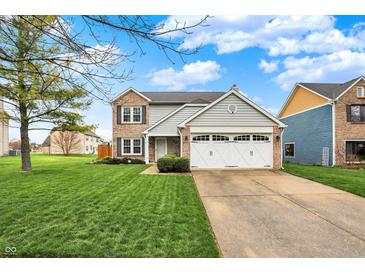 Charming two-story home boasts a manicured lawn, two-car garage, and inviting curb appeal at 5223 Jerry Ct, Indianapolis, IN 46254