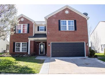 Charming two-story brick home featuring a well-maintained lawn, black shutters, and attached two-car garage at 10105 Yosemite Ln, Indianapolis, IN 46234