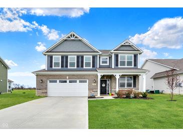 Charming two-story home with a manicured lawn, brick and gray siding, and a two-car garage at 1691 Beyers St, Fortville, IN 46040