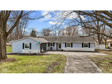 Charming single-story home featuring light blue siding, dark shutters, a fountain, and a paved driveway at 1707 W 76Th Pl, Indianapolis, IN 46260