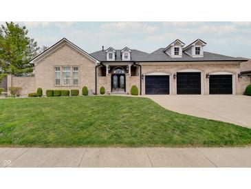 Charming brick home with a well-manicured lawn and a three-car garage, perfect for Gathering living at 6802 Carters Grove Dr, Noblesville, IN 46062