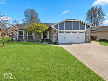 Charming single-story home with brick facade, manicured lawn, and two-car garage at 919 Oak Park Dr, Shelbyville, IN 46176