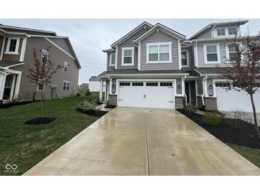 Charming gray two-story townhouse featuring a white two car garage and concrete driveway at 1268 Newton St, Avon, IN 46123