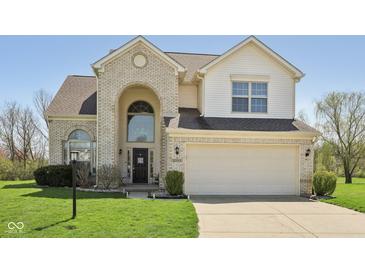 Traditional two-story home featuring a brick facade, attached two-car garage and a well-maintained lawn at 13351 Grosbeak Ct, Carmel, IN 46033