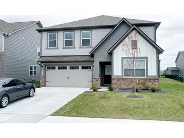 Two-story home featuring gray siding, a two-car garage, and a well-manicured lawn at 15702 Cobbs Crk Ln, Noblesville, IN 46060