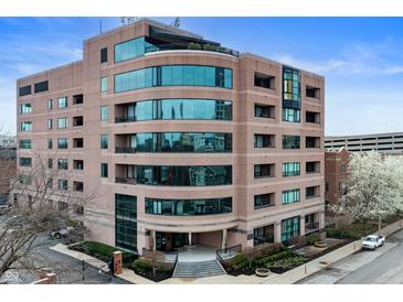Modern building with curved architectural glass, manicured landscaping, and inviting entrance at 225 N New Jersey St # Apt 48, Indianapolis, IN 46204