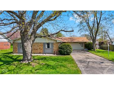 Charming single-story brick home with mature tree, green lawn, and driveway leading to attached garage at 2753 N High School Rd, Indianapolis, IN 46224