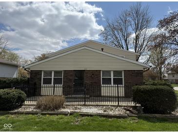Charming single-story brick home with a black fence and well-maintained front yard on a sunny day at 3333 Lupine Dr, Indianapolis, IN 46224