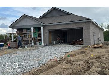 New construction home with stone brick exterior, attached garage and unfinished yard at 3949 Donaldson Creek Ct, Clayton, IN 46118