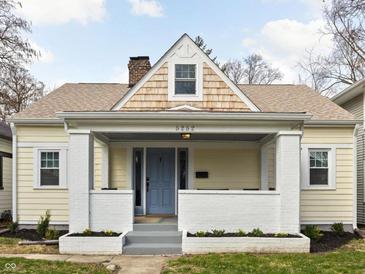 Charming home featuring a gabled roof, covered porch with brick accents, and a well-maintained front yard at 5252 N College Ave, Indianapolis, IN 46220