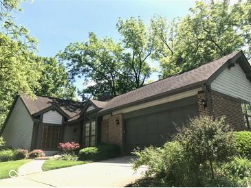 A brick and siding home with an attached garage and mature landscaping at 5329 Hawks Point Rd, Indianapolis, IN 46226
