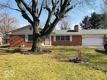 Charming single-story brick home with attached garage, mature tree in the front yard, and well-maintained lawn at 709 Braugham Rd, Indianapolis, IN 46227