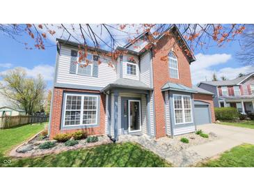 Charming two-story home with brick and vinyl siding and a well-manicured lawn in a lovely neighborhood at 716 Bristol Ct, Greenwood, IN 46143