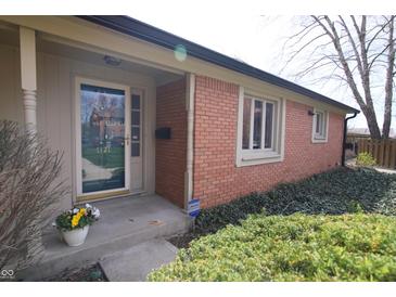 Charming brick home with a welcoming front door and lovely landscaping at 1121 Canterbury Ct, Indianapolis, IN 46260