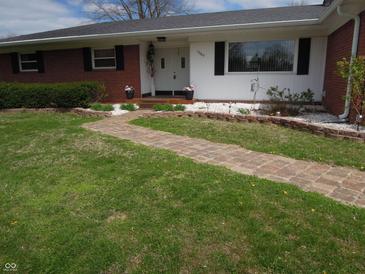 Well-maintained home featuring a brick pathway leading to the front entrance, landscaped with decorative stones and greenery at 13065 Allman Dr, Mooresville, IN 46158