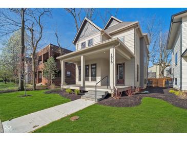 Charming home boasts a welcoming front porch and professionally landscaped yard at 1818 Central Ave, Indianapolis, IN 46202