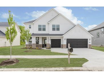 Stunning two-story white home featuring a two-car garage and well-manicured lawn with young tree at 18944 Seaforth Way, Westfield, IN 46074