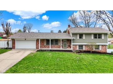 Charming home with an attached garage, green lawn, brick facade, and a welcoming front porch at 2001 Winchester Dr, Indianapolis, IN 46227