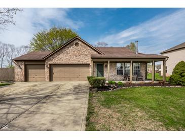 Charming brick home featuring a two-car garage, covered porch, and well-maintained lawn at 2034 Milburn Dr, Brownsburg, IN 46112
