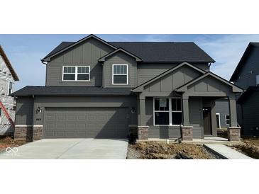 Two-story home featuring a gray exterior, a two-car garage, and a covered front porch at 2759 Evergreen Ave, Plainfield, IN 46168