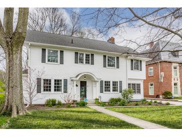 Charming two-story white home with a well-manicured lawn and traditional architectural details at 4451 N Washington Blvd, Indianapolis, IN 46205