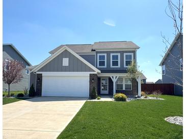 Charming two-story home with a well-manicured lawn, attached garage, and inviting front entrance at 5493 W Woodhaven Dr, McCordsville, IN 46055