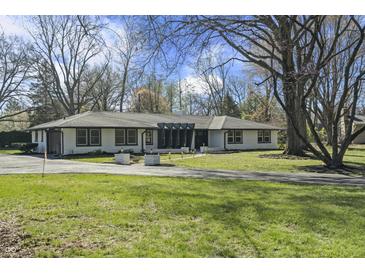 Classic ranch home with a long, paved driveway, complemented by a lush, green lawn at 6025 Crows Nest Dr, Indianapolis, IN 46228
