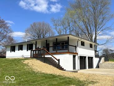 Charming white brick home with a manicured lawn, covered porch, and a two-car garage at 7440 S 250 W, Pendleton, IN 46064