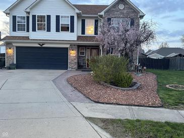Charming two-story home featuring a well-manicured lawn, a dark garage door, and a brick and siding facade at 82 Pin Oak Ct, Whiteland, IN 46184