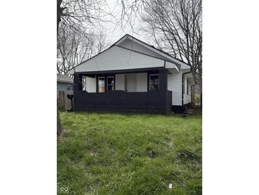 Cozy single-story home featuring a quaint front porch with white siding and a well-maintained lawn at 1032 Groff Ave, Indianapolis, IN 46222