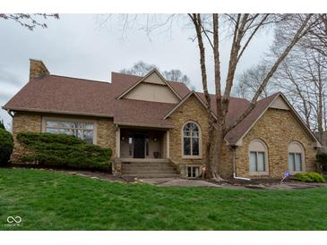 Charming stone home with a well-maintained lawn and inviting entryway at 11203 Westminster Way, Carmel, IN 46033