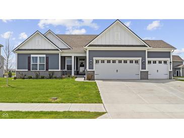 Charming single-story home with a three-car garage and well-manicured lawn at 19405 Titus Dr, Westfield, IN 46074