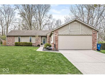 Charming single-story home featuring brick and siding exterior, well-manicured lawn, and attached two-car garage at 334 Stonehedge Dr, Carmel, IN 46032