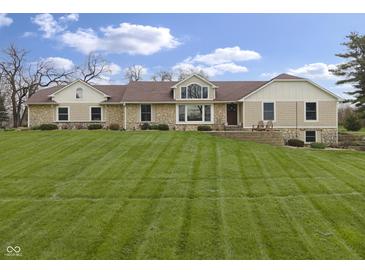 Charming stone and siding home featuring a well manicured lawn and inviting front entrance at 5455 S 800 E, Zionsville, IN 46077