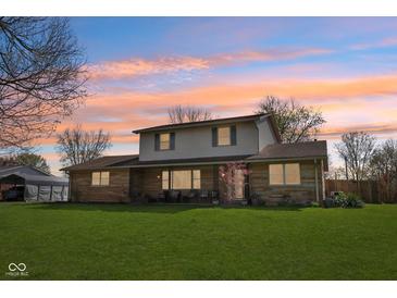Charming two-story home featuring a covered front porch and a spacious green lawn at 5831 Bar Del W Dr, Indianapolis, IN 46221