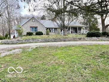 Charming stone and siding home with a welcoming front porch and well-maintained landscaping at 5846 Bellsville Pike, Columbus, IN 47201