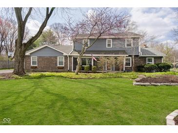 Charming two-story home with landscaped front yard, brick accents, and mature trees at 9270 N Temple Ave, Indianapolis, IN 46240