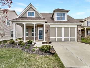 Charming two-story home with a brick and siding facade, covered porch, and well-maintained landscaping at 12521 Hawks Landing Dr, Fishers, IN 46037