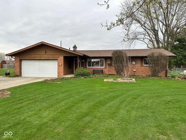Charming brick ranch-style home with an attached garage and a well-manicured lawn at 5626 Hammon Dr, Brownsburg, IN 46112