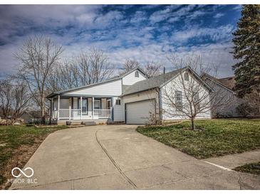 Charming home featuring white siding, a spacious front yard, and an attached two-car garage at 5752 Echo Way, Indianapolis, IN 46278