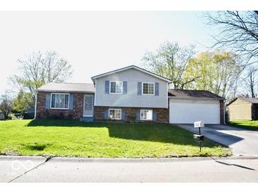 Charming split-level home with a well-maintained lawn and an attached two-car garage at 7838 Burr Oak Ct, Indianapolis, IN 46217