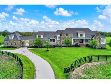 Expansive stone home features a long driveway and lush green lawn at 1581 S 825 E, Zionsville, IN 46077