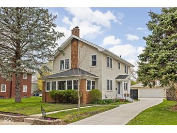 Beautiful two-story house featuring vinyl siding, a long driveway and lush greenery in a residential neighborhood at 310 W 43Rd St, Indianapolis, IN 46208