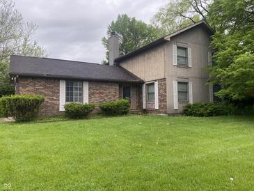Two-story home with a well-maintained lawn, trimmed bushes, and brick accents at 3202 Acacia Dr, Indianapolis, IN 46214