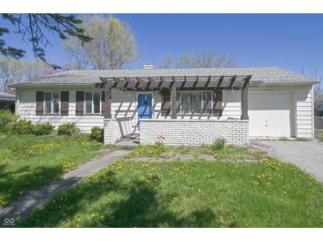 Charming single-story home with a blue door, brick accents, and a well-lit front yard at 3550 Winings Ave, Indianapolis, IN 46221